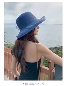 Detail of the woven texture and wavy brim on this elegant blue summer beach sun hat