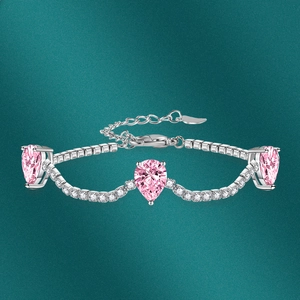 Macro shot of silver bracelet with pink pear-cut crystals and white pave stones