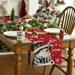 Detailed view of red Christmas table runner with snowman illustration and Let It Snow text