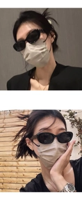 Detail of black oval cat-eye sunglasses with dark UV lenses and glossy finish