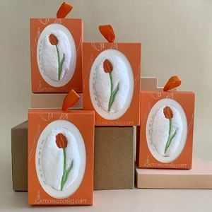 Orange gift box set containing white coral fleece towels with tulip embroidery details