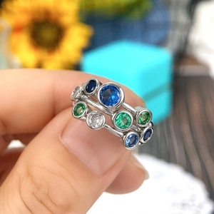 Detail shot of multi-color gemstones set on a silver metal ring worn on the finger