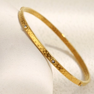 18K gold plated stainless steel bangle featuring hammered texture and circular diamonds