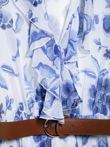 Détail d'une robe à imprimé floral bleu avec encolure à volants et ceinture marron