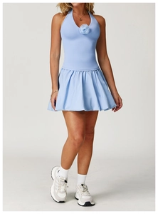 Detail of light blue tennis dress featuring a halter neck and 3D floral accent on the neckline