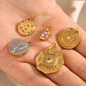 Detail view of 18K gold and silver coin pendants with square zircon and Queen engraving