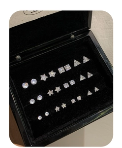 Close-up of geometric zircon stud earrings set in various shapes and sizes on black velvet