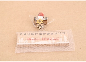 Detail of wooden Christmas countdown calendar featuring a gnome and Merry Christmas text