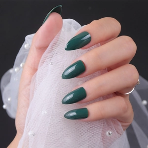 Macro detail of glossy dark green stiletto nails with elegant white lace photography prop