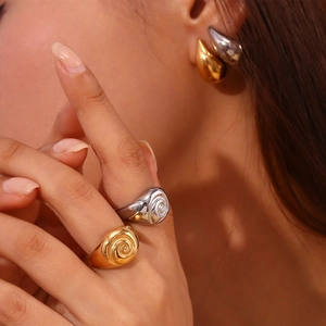 Macro detail of 18K gold and silver plated spiral ring with teardrop drop earrings