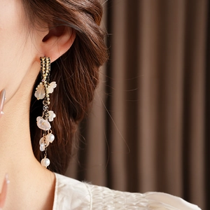 Detailed view of elegant gold tassel earrings with pearls and floral crystal accents