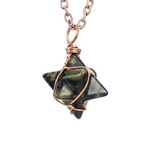 Macro detail of hand-wrapped copper wire on a star-shaped green natural stone pendant