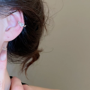 Detail view of heart zircon ear cuff with petal stud on model's ear in silver finish