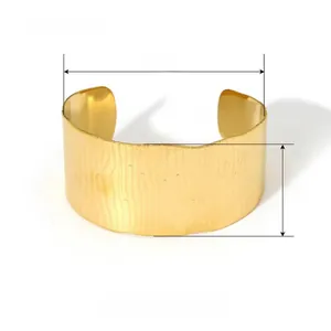Detail view of a 30mm wide textured gold cuff bracelet showing 62mm diameter and 39g weight