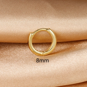 Minimalist 18k gold polished 8mm hoop earring on elegant champagne silk fabric