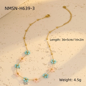Detail view of light luxury floral necklace with blue and pink beads and gold lobster clasp