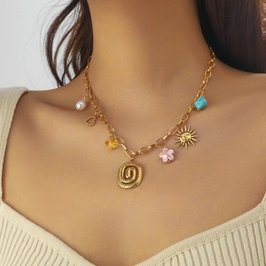 Gold spiral sun and face pendant necklace with colorful acrylic charms on a model