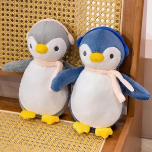 Detailed texture of cute plush penguin dolls with earmuffs and scarf on a wicker chair