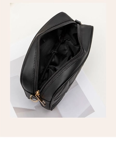 Detail of black quilted shoulder bag interior with gold zipper and spacious lining