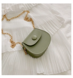 Détail d'un mini sac selle vert menthe avec une épaisse bandoulière chaîne dorée