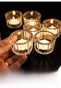 Primo piano del portacandele in vetro cristallo a costine con calda luce di candela