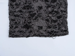 Gros plan sur un tissu en maille grise déchirée avec une doublure noire contrastée