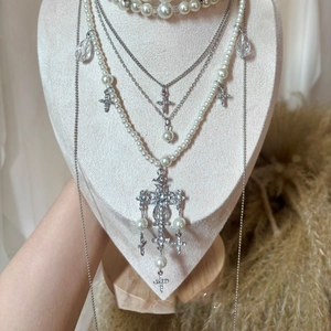 Detailed close-up of multilayer Baroque pearl necklace with crystal cross pendants