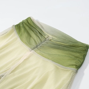 Detail of green and yellow pleated mesh fabric with a concealed zipper closure