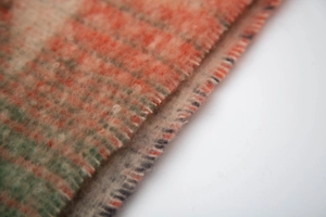 Macro detail of high-quality brushed boucle scarf fabric with gradient star pattern texture