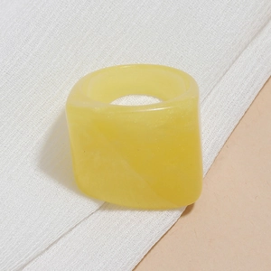 Detailed view of chunky lemon yellow resin ring with smooth pearlescent finish