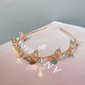Detailed macro view of golden metal headband with hollow 3D butterfly ornaments