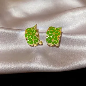 Elegant green enamel C-shaped flower hoop earrings with gold-plated metallic accents