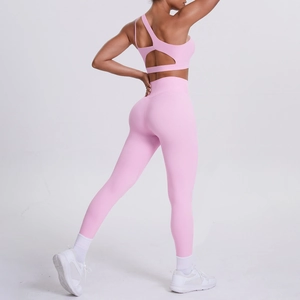 Detail of light pink one-shoulder yoga bra and high-waist seamless leggings on model