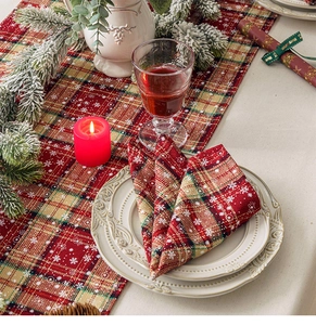 Close-up of linen Christmas table runner and placemat with plaid snowflake patterns
