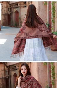 Dettaglio scialle rosso in finto cashmere con motivo paisley e frange su via retrò