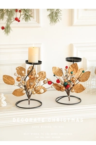 Detailed view of gold leaf metal candle holders with festive berry ornaments for Xmas decor