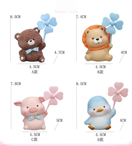 Detailed view of four cute resin animal figurines including bear and lion with windmills