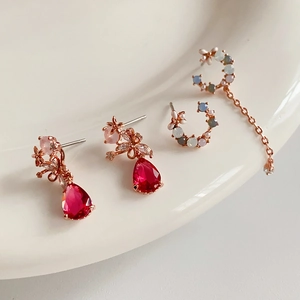 Dettaglio del set di orecchini floreali in zircone con finitura oro rosa su vassoio bianco