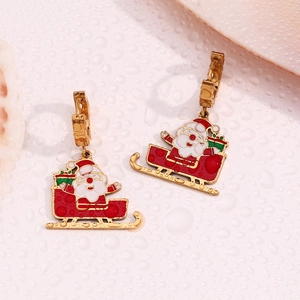 Gros plan sur les boucles d'oreilles Père Noël en traîneau dorées et détails en émail