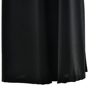 Gros plan de l'ourlet de la robe noire montrant le tissu drapé et la texture de qualité