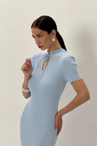 Dettaglio di un abito in maglia azzurro con trama verticale e scollatura con lacci