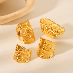 Set of four textured gold stainless steel rings with hammered and wave patterns