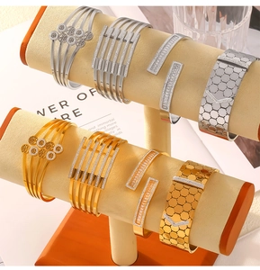 Close-up of geometric titanium steel bracelets with hollow designs and zircon inlays