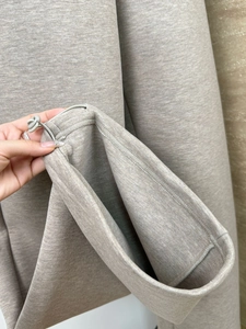 Macro shot of oatmeal knit fabric texture with adjustable drawstring and plastic toggle