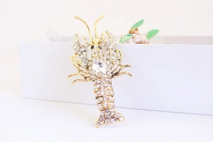 Macro detail of a golden lobster keychain with sparkling white crystals and large oval stone