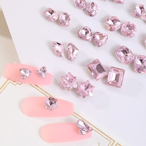 Close-up of assorted pink rhinestone nail charms in heart, square and flower shapes