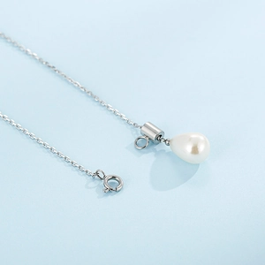 Elegant silver tassel Y-necklace featuring a white teardrop pearl on light blue background