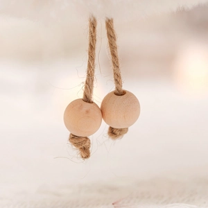 Close-up of natural wooden beads and rustic jute rope on a Christmas hanging ornament