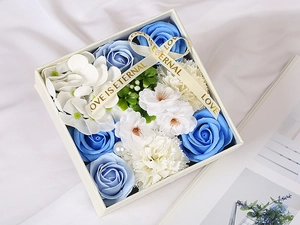 Macro detail of blue and white soap flower gift box with Love Is Eternal ribbon and pearl