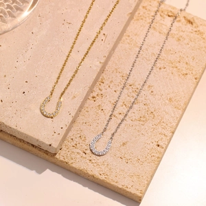Elegant U-shaped horseshoe pendant necklace in gold and silver with sparkling cubic zirconia